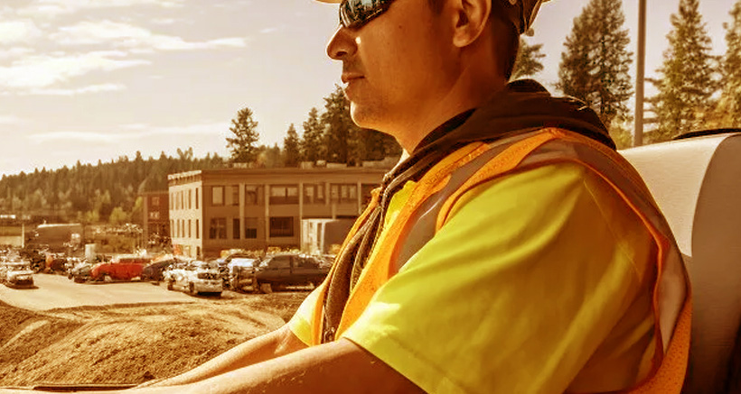 Homme dans excavatrice sur chantier de construction